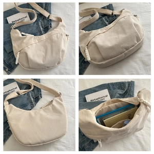 Aperçu détaillé d'un sac demi-lune en velours côtelé crème montrant texture et intérieur