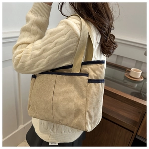 Détail du sac fourre-tout en velours côtelé kaki clair avec bordure noire et poches