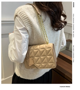 Détail du sac beige clair à matelassage triangulaire avec bandoulière en chaîne dorée