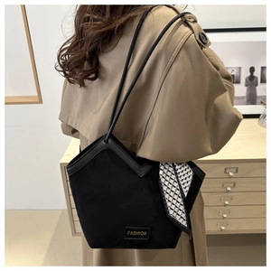 Detail of black tote bag with V-cut top, silk scarf accessory and fashion label