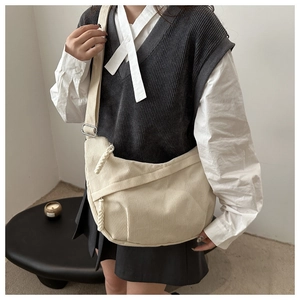Détail du sac beige en velours côtelé montrant la texture et la boucle en métal
