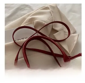 Close-up of white and red tote bag with embossed texture and gold logo lettering