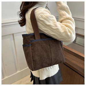 Détail du sac cabas en velours côtelé marron avec poches et liseré bleu marine discret