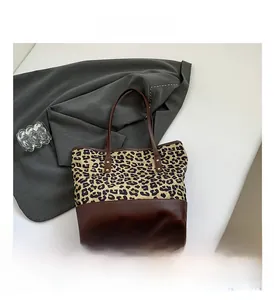 Dettaglio della tela con stampa leopardata e cuciture in pelle marrone scuro sulla borsa