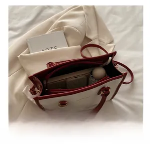 Detail view of contrast color tote bag interior showing spacious capacity for daily items