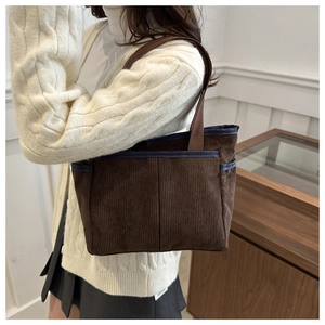 Texture détaillée du sac cabas en velours côtelé marron foncé avec bordure bleu marine