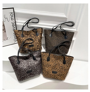 Collection of four leopard print canvas tote bags with black synthetic leather handles