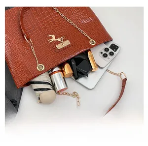 Detail showing the spacious interior of a brown crocodile pattern tote bag with golden accents
