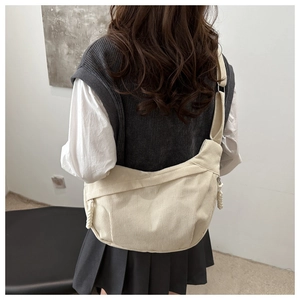 Vue détaillée du sac demi-lune en velours côtelé blanc crème avec bandoulière réglable