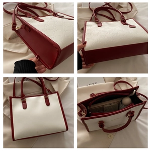 Macro view of contrast color tote bag showing spacious interior and embossed bow details