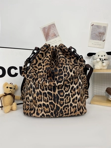 Detail of leopard print bucket bag with drawstring closure and crossbody strap