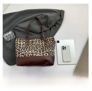Dettaglio della borsa shopper leopardata con base in pelle marrone e borchie piatte