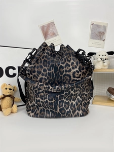 Macro detail of leopard print bucket bag with black chunky chain and drawstring closure