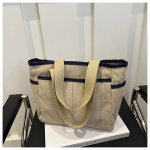 Détail du sac cabas en velours côtelé beige avec poches latérales et bordure bleue