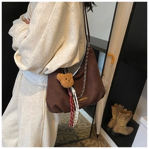 Détail du sac bandoulière en daim en forme de lune avec bandoulière à chaîne dorée