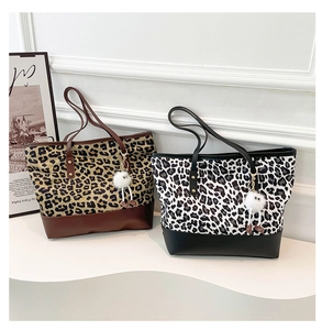 Dettaglio borse shopper leopardate marroni e nere con ciondoli in peluche morbidi