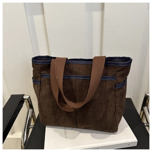 Détail du sac cabas en velours côtelé marron foncé avec texture rayée et poches avant