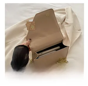 Vue détaillée de l'intérieur du sac beige avec espace pour téléphone et chaîne dorée
