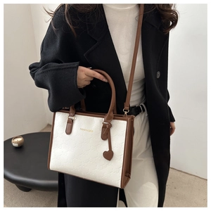 Detail of contrast stitching tote bag with bow texture and fashion lettering for women