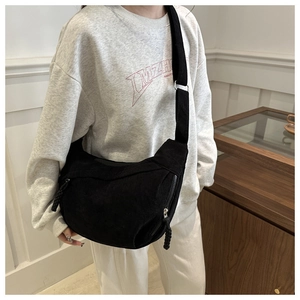 Détail du sac bandoulière en velours noir avec fermeture en corde tressée et texture