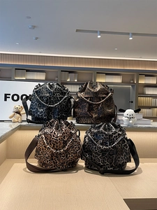 Detail view of four leopard print drawstring bucket bags in various color schemes