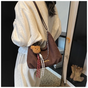 Vue détaillée du sac cabas en daim marron avec breloque ours et détails en corde tressée