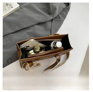 Internal view of brown quilted tote bag showing large capacity for phone and cosmetics