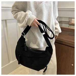Détail du sac croissant en velours côtelé noir avec boucle en métal et tissu texturé