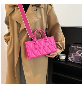 Detail of rose pink crossbody bag with geometric quilted pattern worn by a model