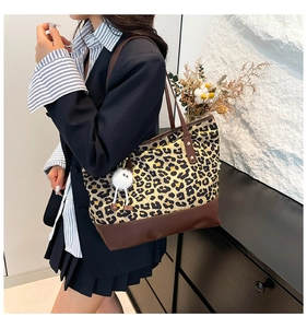 Dettaglio della borsa tote leopardata con base in ecopelle marrone e ciondolo peluche