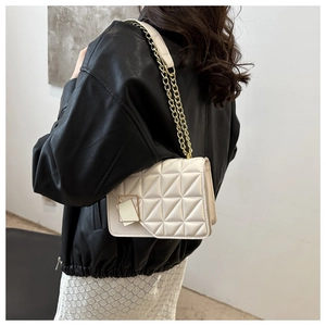Sac bandoulière en cuir matelassé blanc cassé avec chaîne dorée sur un mannequin