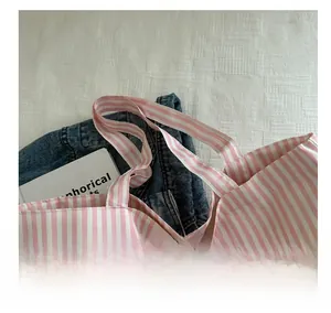 Detail of pink and white striped canvas tote bag showing soft handles and woven texture