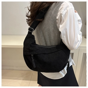Détail de la sacoche croissant en velours côtelé noir avec large bandoulière réglable