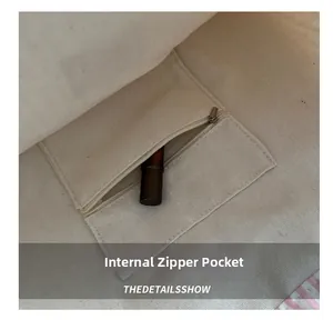 Detail view of the interior zip pocket in a canvas tote bag showing storage capacity