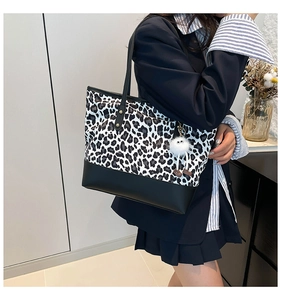 Dettaglio della borsa tote leopardata con ciondolo di peluche e base in pelle