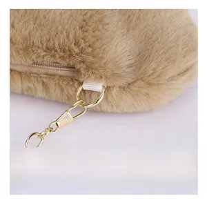 Close-up of premium gold-tone metal zipper and chain detail on khaki plush cloud bag