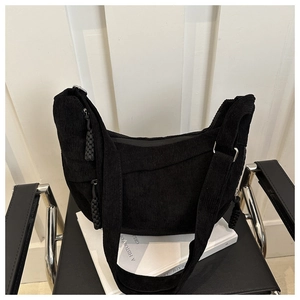 Gros plan du sac porté épaule en velours côtelé noir avec détail de fermeture à nœud
