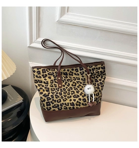 Dettaglio della borsa tote leopardata con finiture in ecopelle marrone e ciondolo in peluche