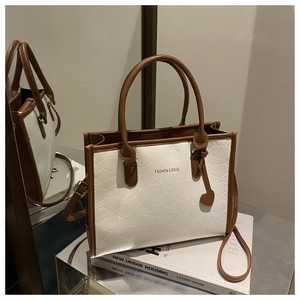 Close-up of contrast tote bag featuring 3D bow texture and stylish heart charm detail