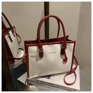 Close-up of contrast color tote bag with bow relief pattern and heart charm detail