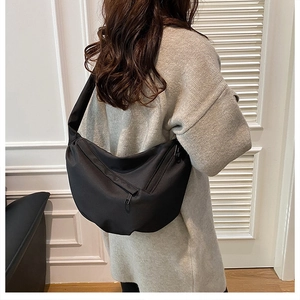 Detail of black crescent crossbody bag showing spacious compartments and adjustable strap