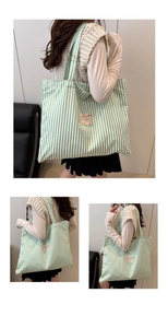 Detail of green and white striped canvas tote bag showing the label and durable fabric