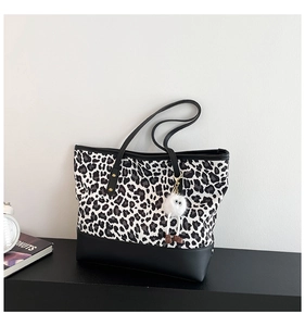 Dettaglio della borsa leopardata con base in pelle nera e ciondolo a forma di mostro peloso