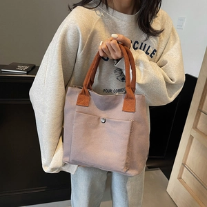 Sac fourre-tout en toile violette avec anses oranges et poche avant pour usage quotidien