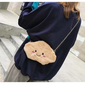 Brown plush cloud-shaped crossbody bag with cartoon face shown on a female model