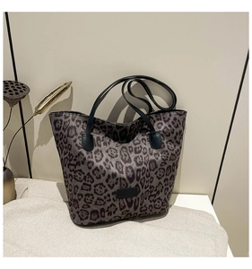 Macro detail of animal leopard print tote bag with premium leather straps on a display