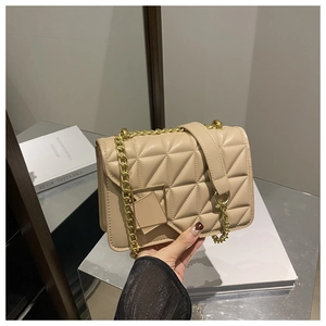 Gros plan détaillé du sac bandoulière matelassé beige avec boucle en métal doré