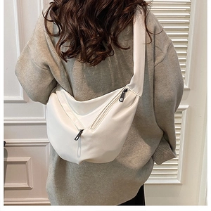 Rear view of a model wearing a white crescent-shaped crossbody bag with soft matte PU leather