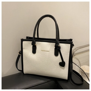 Detail of embossed bow texture and golden lettering on black and white contrast tote bag