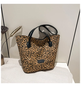 Detail of leopard print tote bag with stylish black straps and textured animal pattern